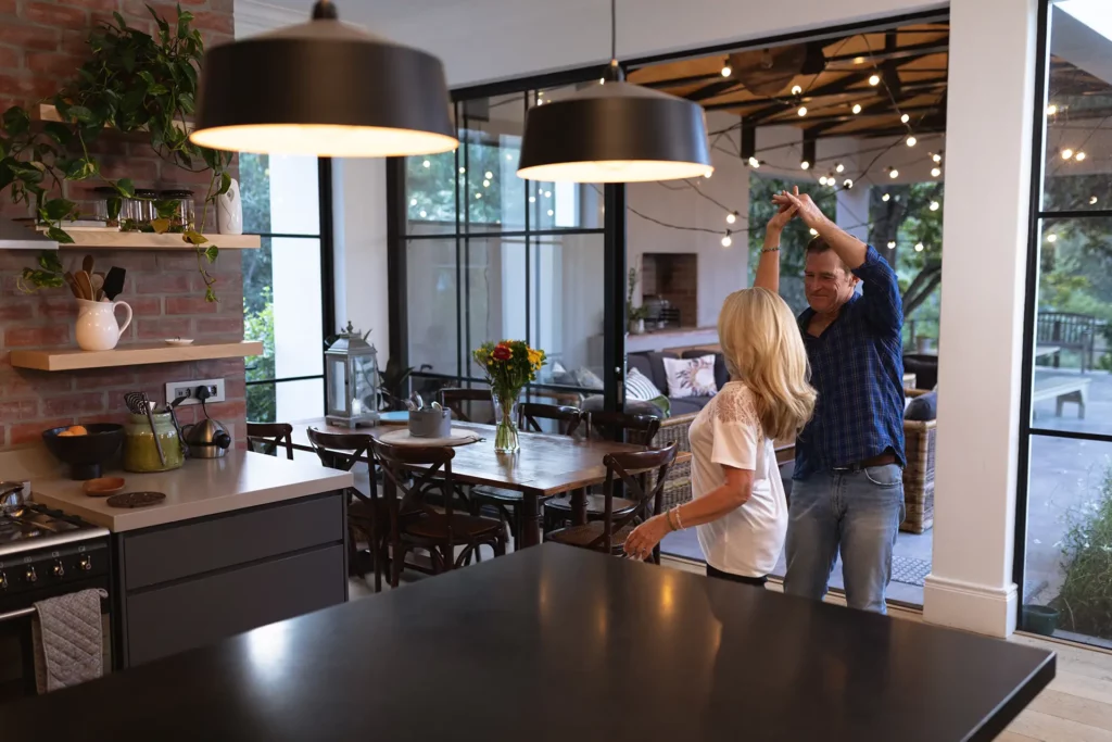 Couple dancing in a modern kitchen with hanging lights